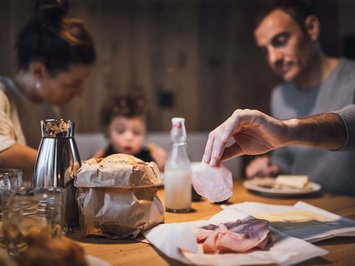 Bontà locali e di stagione al Klessler’s Famiglia a colazione con pane, formaggio, prosciutto e latte