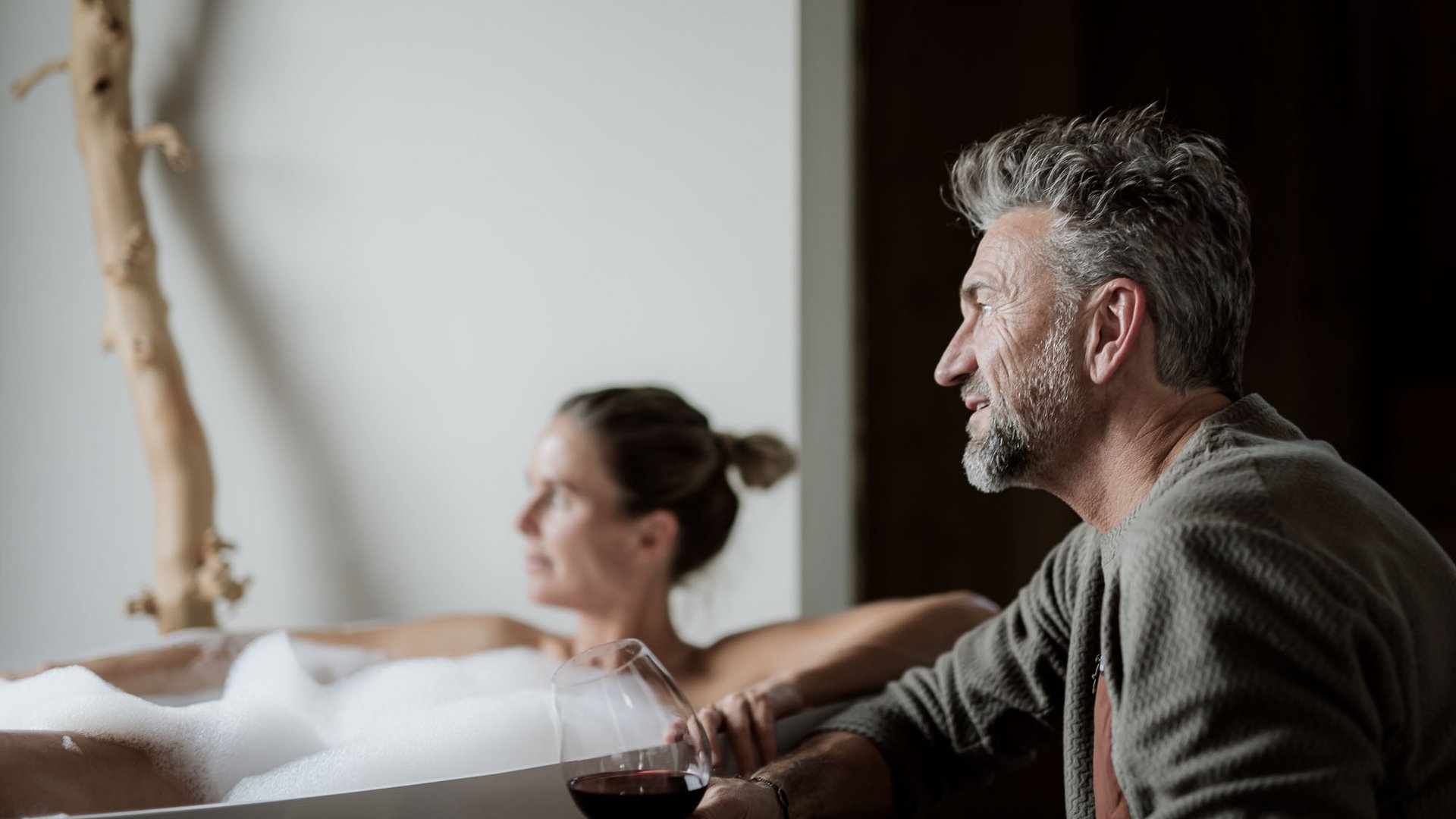 Chalet mit Sauna und noch mehr: Kessler’s Mann mit Rotweinglas neben Frau in Schaumbad