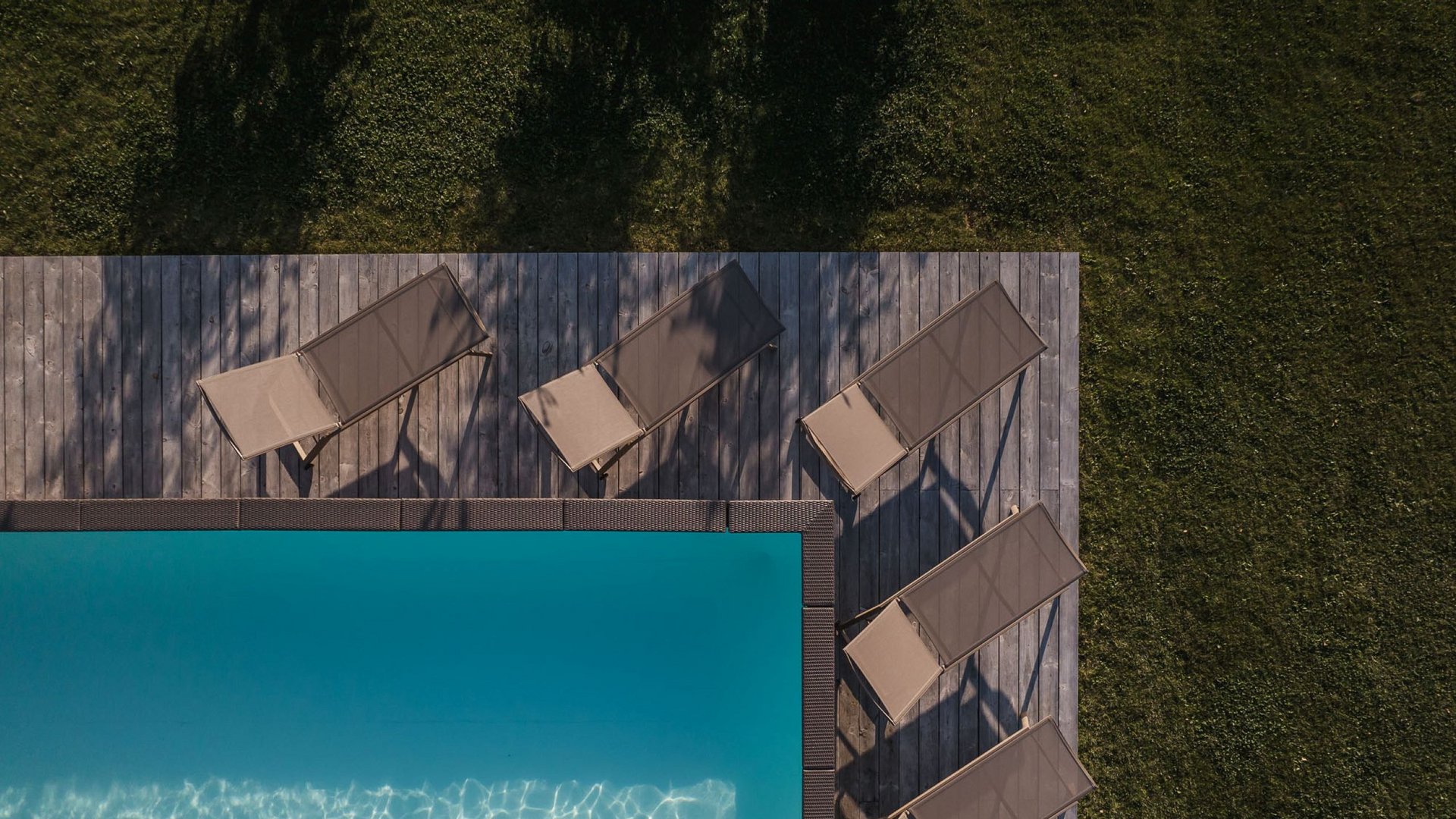 Für Familien Vista aerea di una piscina con sdraio e prato