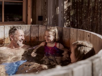 Ferienwohnung in Natz mit dem gewissen Etwas Vater und Töchter im Holzbad im Freien