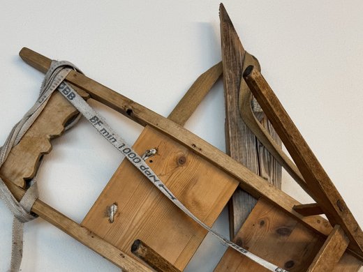 Historical Educational Trail Old wooden stretcher with straps mounted on the wall