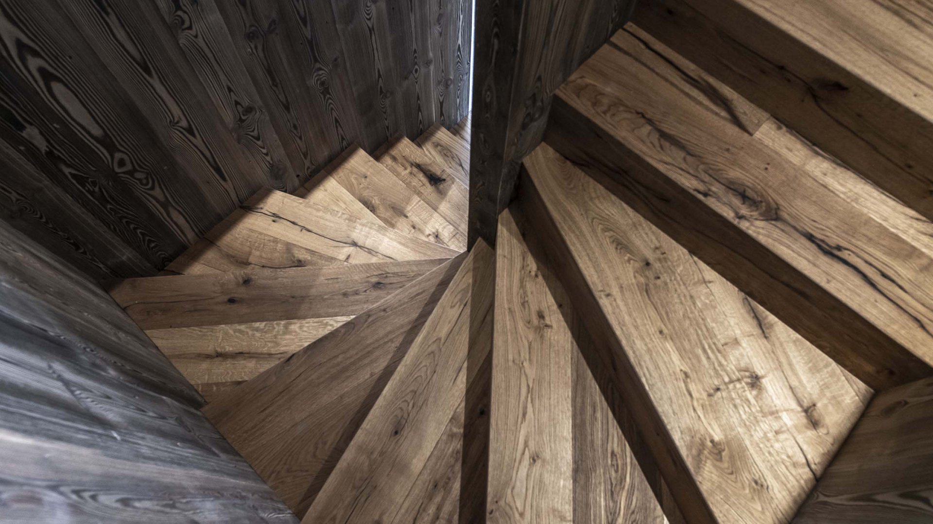 Chalet in Südtirol mit Sauna gesucht? Holztreppe mit dunklen Wänden von oben gesehen