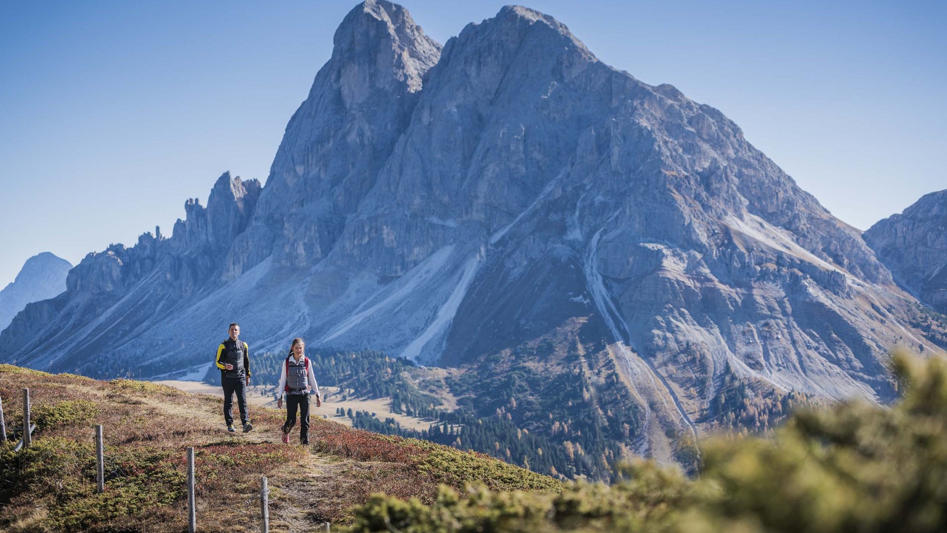 Urlaub mit Hund in Südtirol: Kessler’s! Zwei Wanderer auf Bergpfad mit großer Bergkulisse im Hintergrund