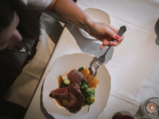 Il ristorante del Kessler: soul-food in stile fresco e sbarazzino Persona mangia bistecca con verdure su piatto bianco a tavola apparecchiata