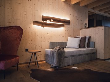 Kessler’s Mountain Lodge: awards Cozy seating area with sofa, armchair, wooden wall, and warm lighting