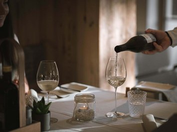 Il ristorante del Kessler: soul-food in stile fresco e sbarazzino Vino bianco versato in un bicchiere in un ristorante