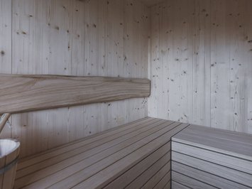 Chalet with a sauna and so much more: Kessler’s Empty wooden sauna interior with wooden bucket and wall clock