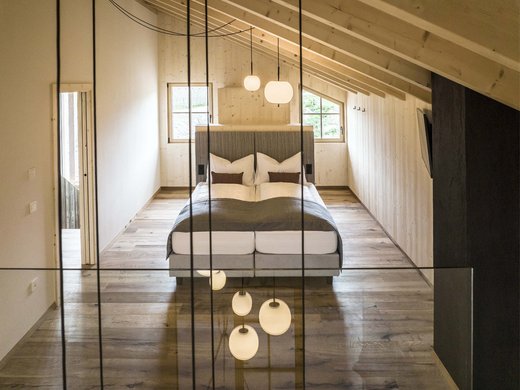 Luxuschalet in Südtirol: willkommen in Kessler’s! Modernes Schlafzimmer mit Holzwänden und Hängelampen