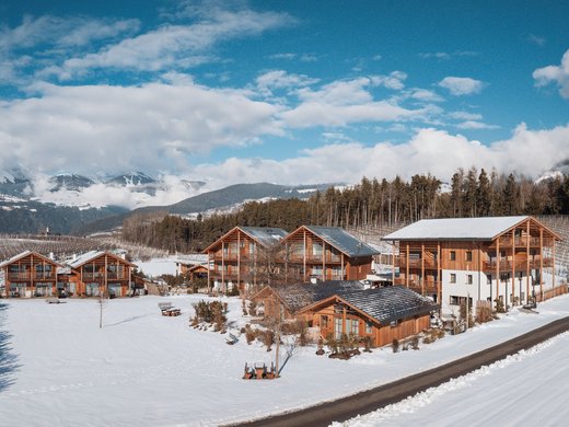 Your holiday apartment in Natz-Schabs: Kessler’s! Wooden houses in a snowy valley with mountains and blue sky in the background