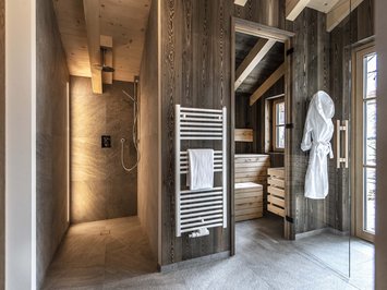 Chalet with a sauna and so much more: Kessler’s Modern wellness area with shower, sauna, towel radiator, and bathrobe