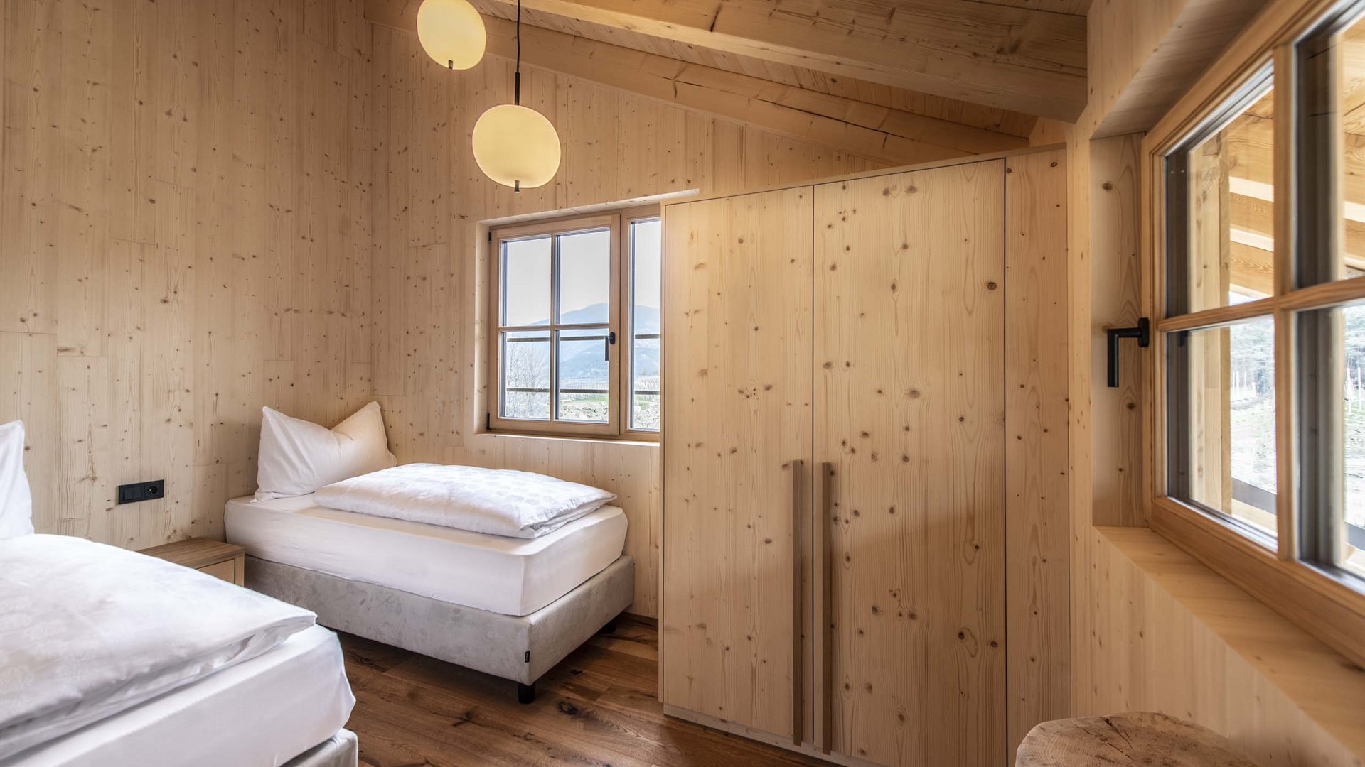 Chalet with a sauna and so much more: Kessler’s Small bedroom with wooden walls, two beds, and window showing mountain view
