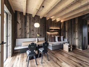 Chalet with a sauna and so much more: Kessler’s Cozy wooden living room with dining area and modern lighting