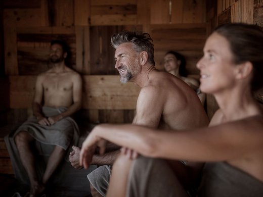 Chalet con sauna privata cercasi? Quattro persone rilassate in una sauna di legno