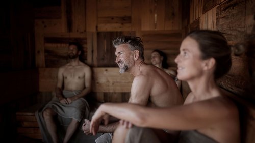 Alpine Tales in the apartment 7=6 Four people relaxing in a wooden sauna room