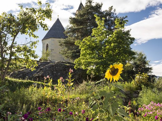 Chalet with a sauna and so much more: Kessler’s Flowers in garden with pointed roof church and trees in background