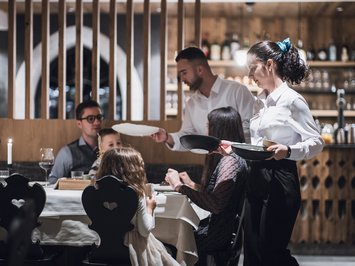 Il ristorante del Kessler: soul-food in stile fresco e sbarazzino Camerieri servono cibo a una famiglia al ristorante