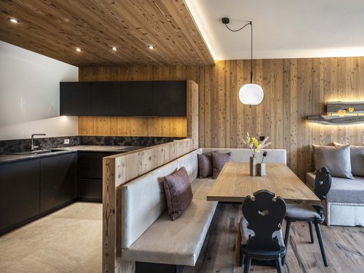 Kessler’s Mountain Lodge: awards Modern living area with integrated kitchen and wood-paneled walls