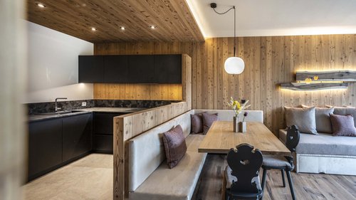 “Premium Terrasse” apartment Modern living area with integrated kitchen and wood-paneled walls