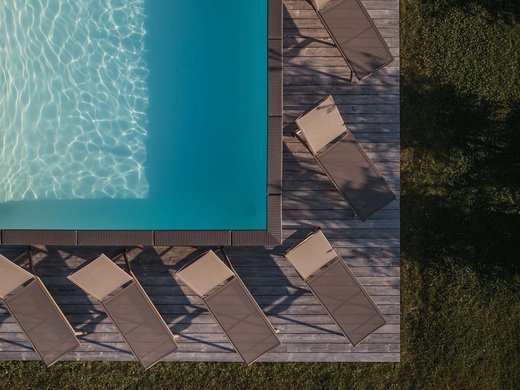 Vacanze in fattoria? Kessler’s Mountain Lodge! Vista aerea di piscina con lettini sul decking in legno e prato attorno