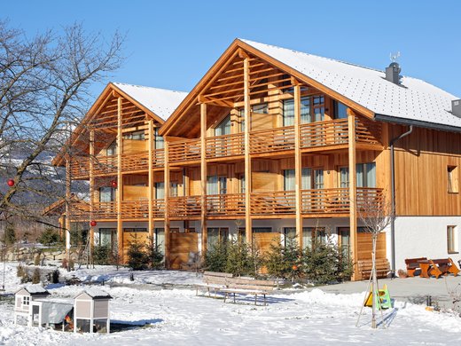 Deine Ferienwohnung in Natz-Schabs: Kessler’s! Holzhaus mit schneebedecktem Dach und Garten im Winter