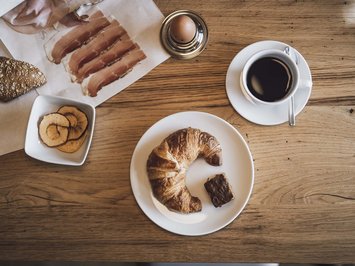 Bontà locali e di stagione al Klessler’s Colazione con croissant, caffè, uovo sodo, prosciutto e fettine di mela