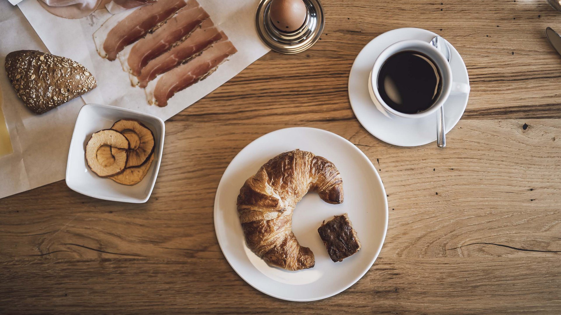 Bontà locali e di stagione al Klessler’s Colazione con croissant, caffè, uovo sodo, prosciutto e fettine di mela