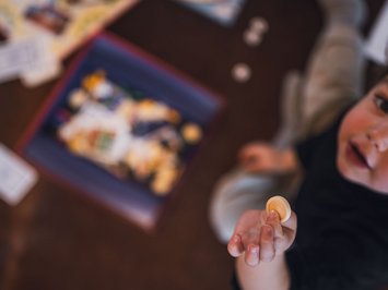 Für Familien Bambino tiene una pedina durante un gioco da tavolo