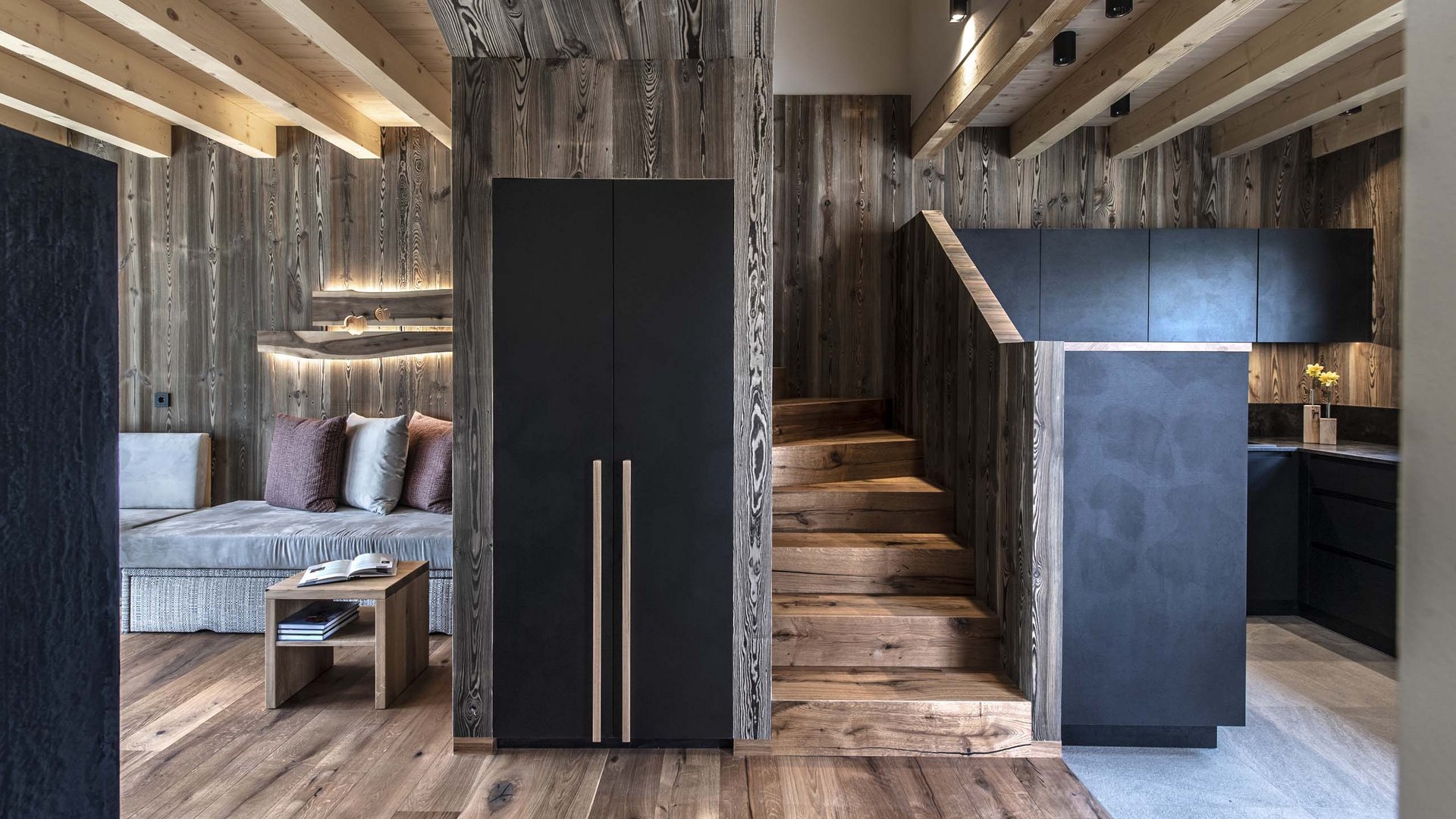 Ferienwohnung in Natz mit dem gewissen Etwas Moderner Wohnbereich mit Holztreppe, Sofa und Küchenzeile in Holzoptik