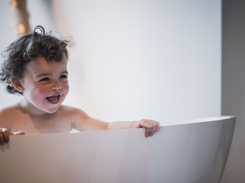 Für Familien Bambino sorridente nella vasca da bagno moderna