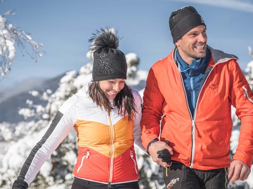 Die Gastgeber deines Chalets bei Brixen Glückliches Paar in Winterjacken beim Spazieren im Schnee