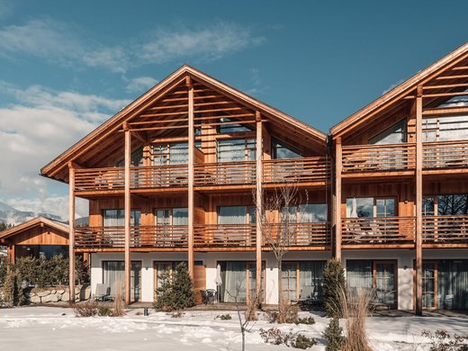 Chalet mit Sauna und noch mehr: Kessler’s Holzchalet mit Balkonen vor verschneiter Berglandschaft