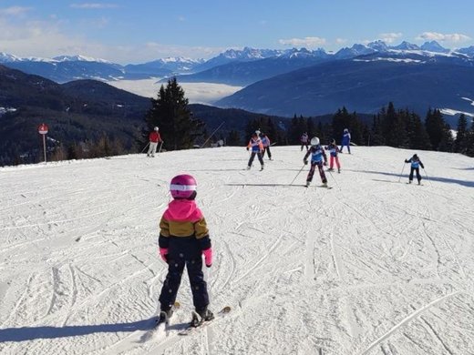 Winter-Highlights Menschen unterschiedlichen Alters Skifahren auf einem schneebedeckten Berg mit Bergkulisse