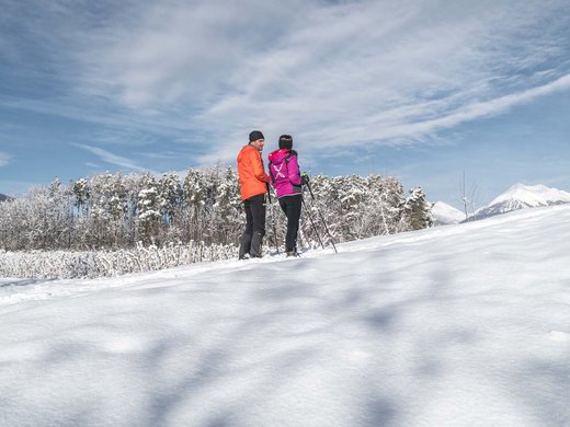 Urlaub nahe Brixen voller Überraschungen Zwei Personen beim Winterwandern im verschneiten Gebirge