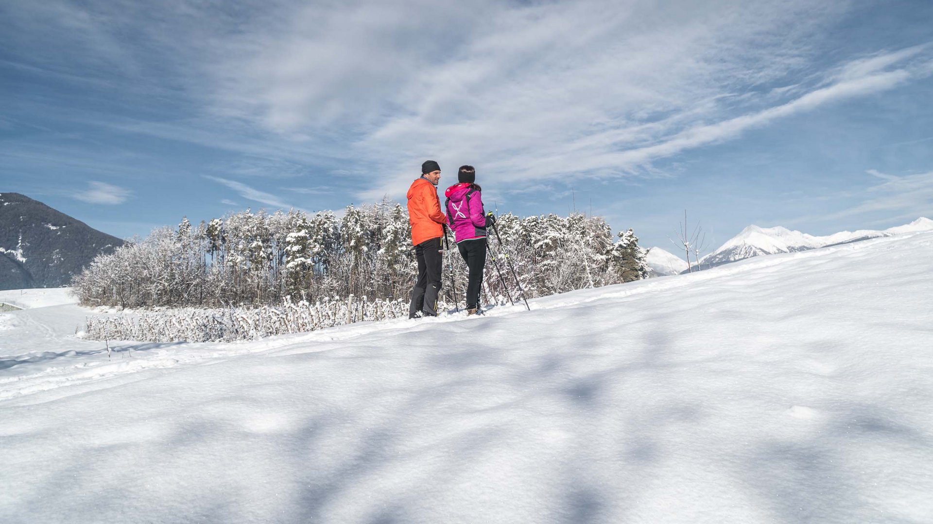 Holiday in Natz-Schabs? Kessler’s Mountain Lodge! Two people hiking in snowy mountain landscape