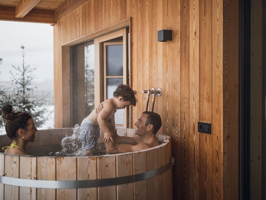 Kessler’s Mountain Lodge: Auszeichnungen Familie im hölzernen Badezuber auf einer Terrasse mit verschneiter Winterlandschaft
