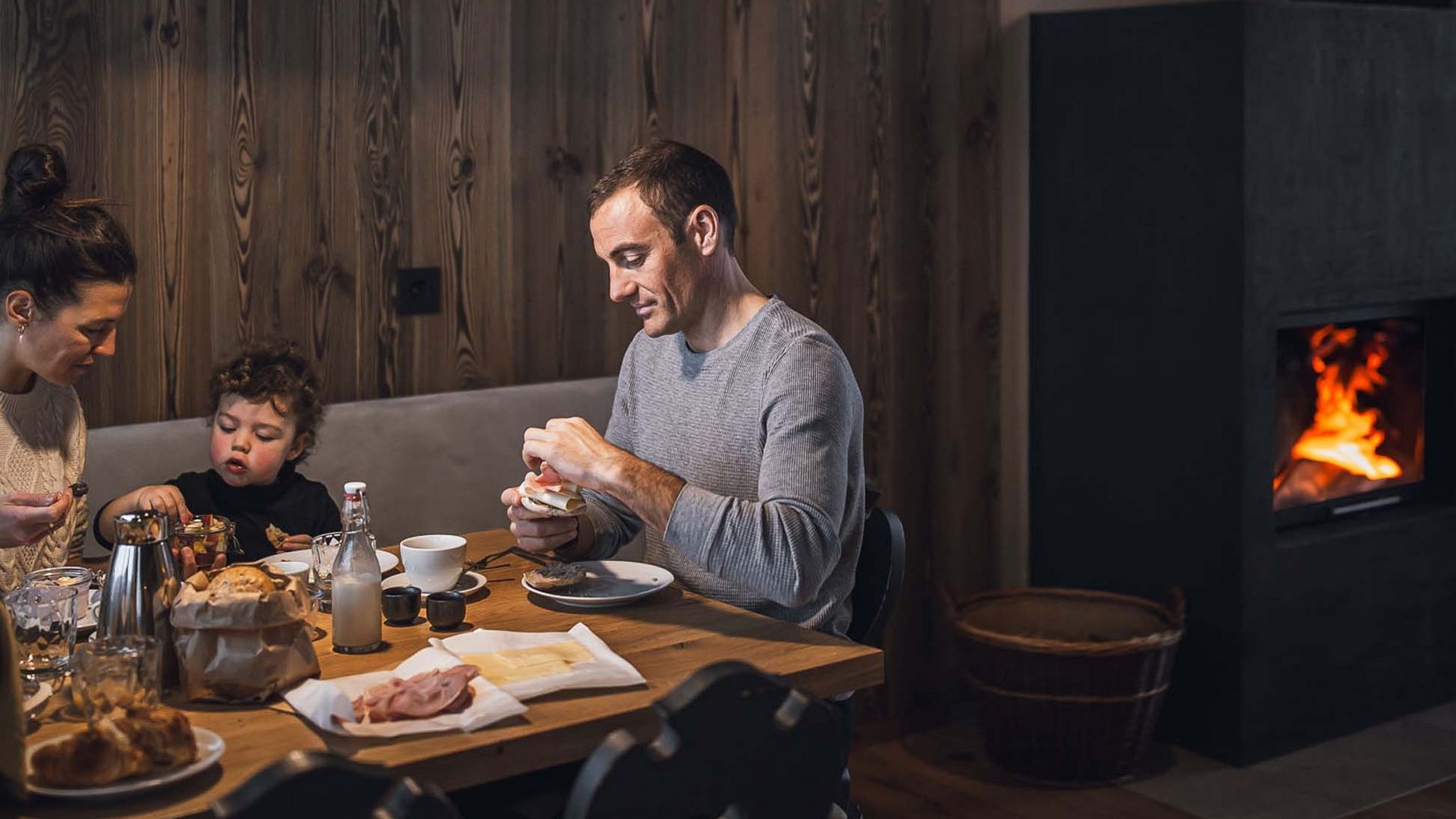 Bontà locali e di stagione al Klessler’s Famiglia che fa colazione insieme a un tavolo di legno vicino al camino