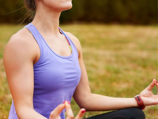 Appartamenti vacanze a Bressanone e dintorni Donna che medita all'aperto su un tappetino da yoga occhi chiusi