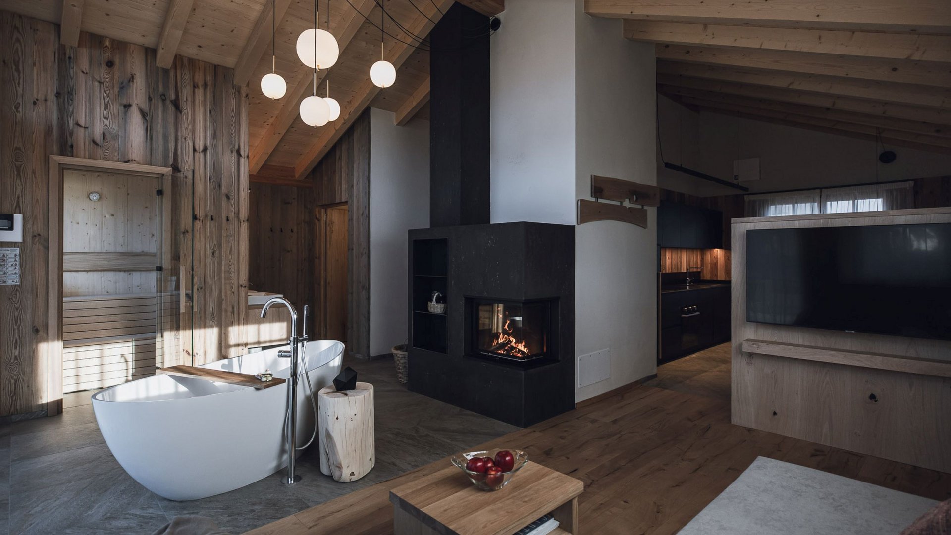 Urlaub in Natz-Schabs? Kessler’s Mountain Lodge! Modernes Wohnzimmer mit Kamin, freistehender Badewanne und Holzdecke